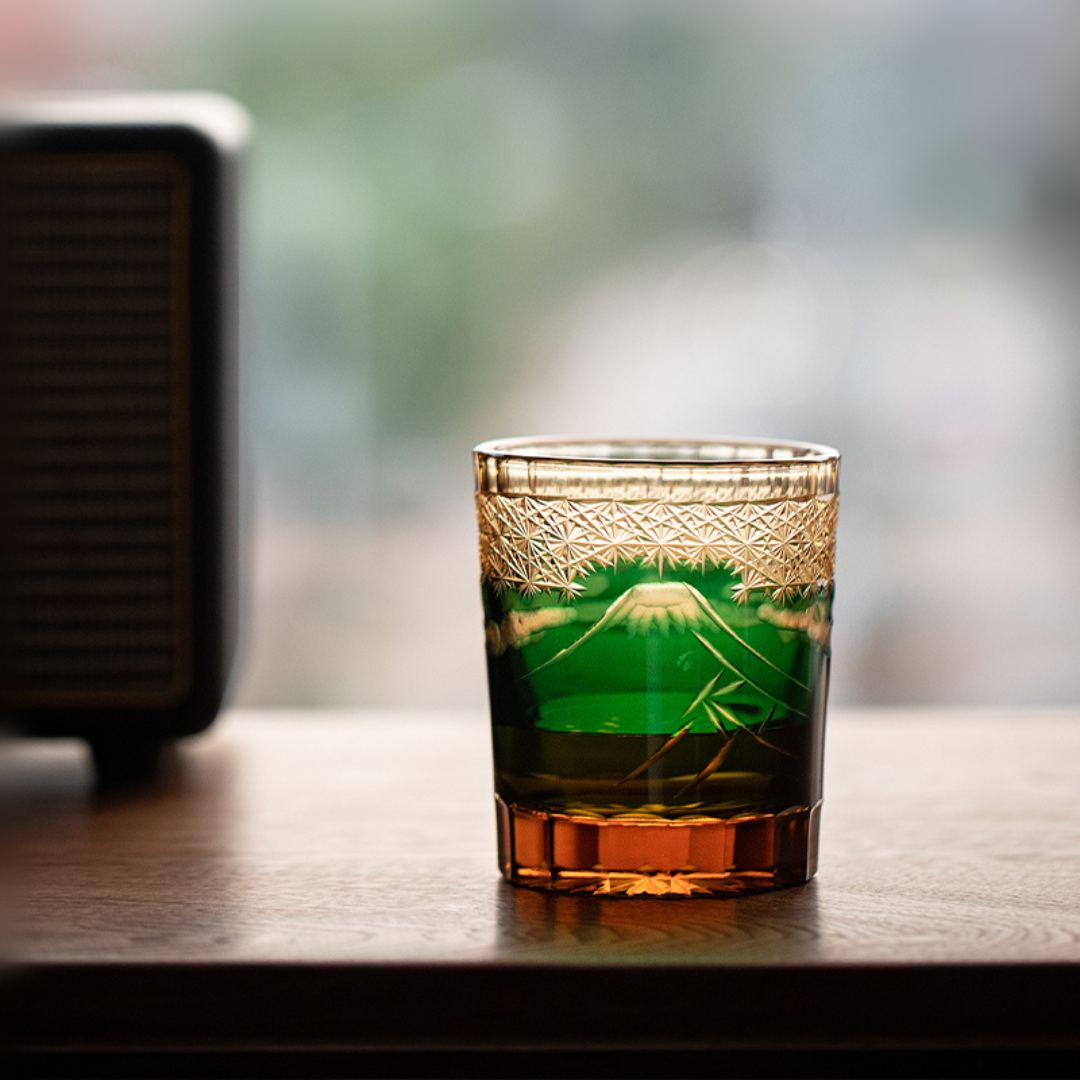 Jade Mount Fuji Glass on wooden surface showing green crystal body, amber base and Mount Fuji design.