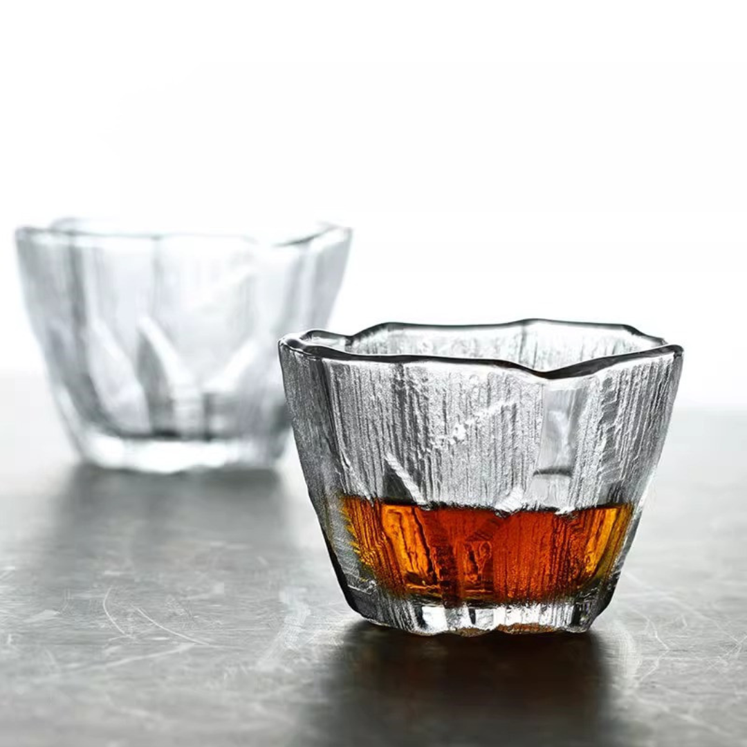 Two handcrafted ice-inspired whisky glass with a unique textured surface, one filled with whisky.