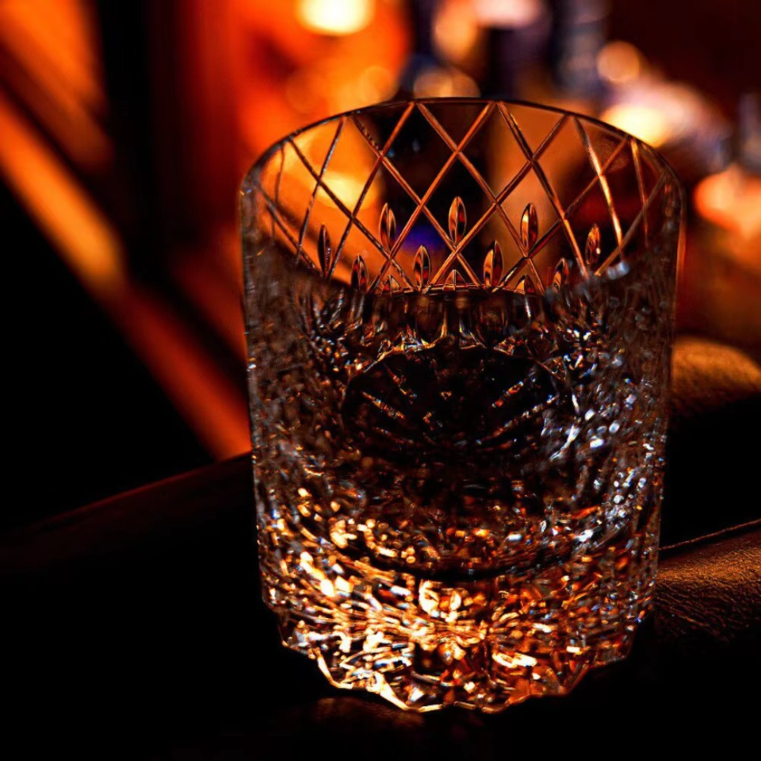 Starry Rain Crystal Whisky Glass with whisky, showing diamond-cut crystal and warm bar lighting.