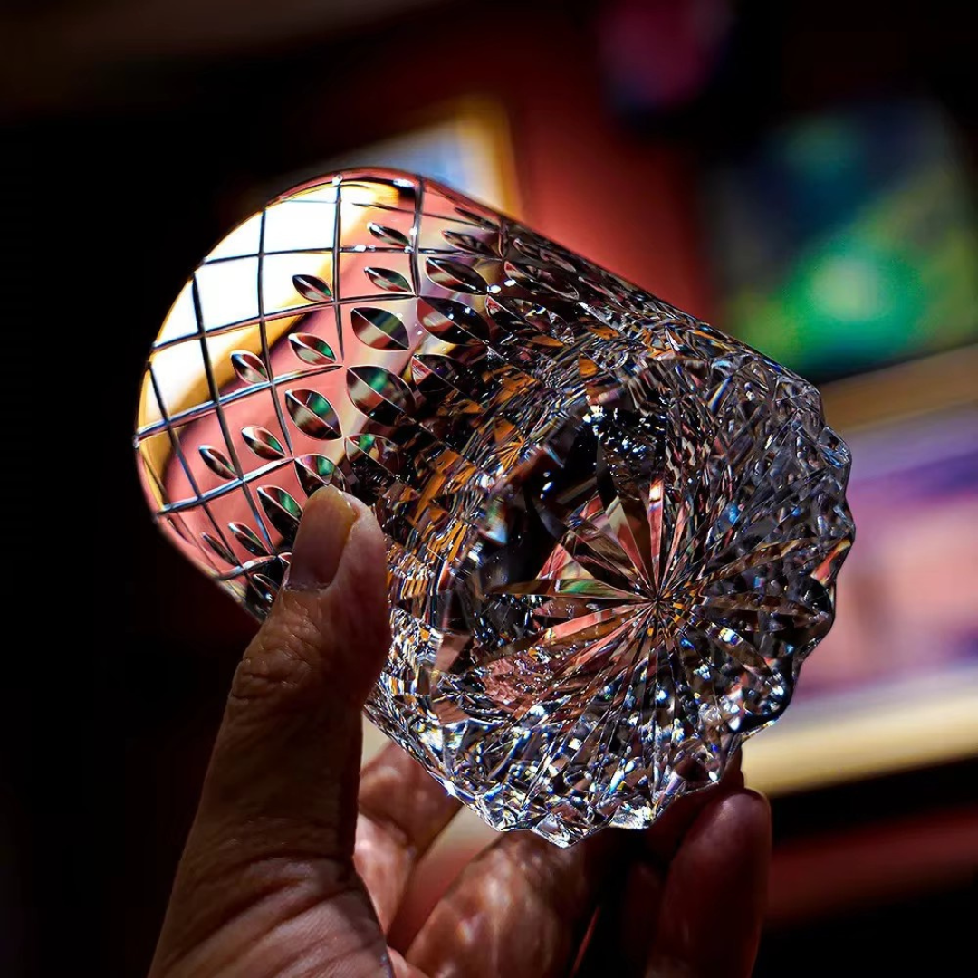 Starry Rain Crystal Whisky Glass close-up showing sculpted base, oval cut pattern and reflective crystal facets.