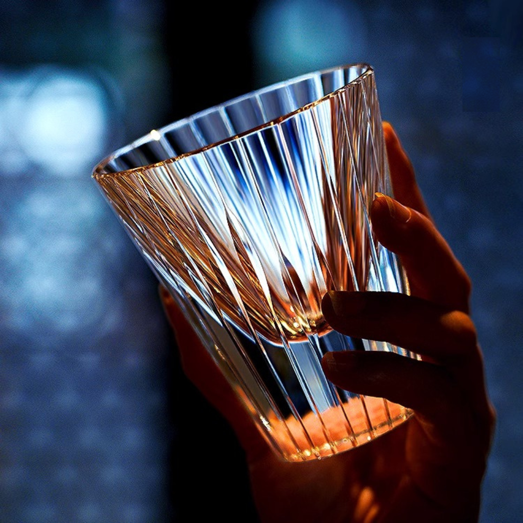 Hand holding our handcrafted crystal whisky glass inspired by the Japanese Koto instrument