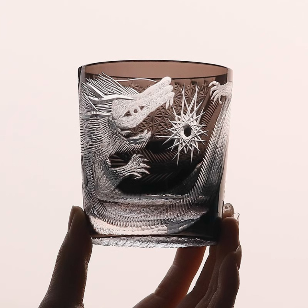 Hand holding our Edo Kiriko Dragon Whisky Glass made from premium K9 crystal, featuring an intricate hand-cut dragon design with sharp detailing.